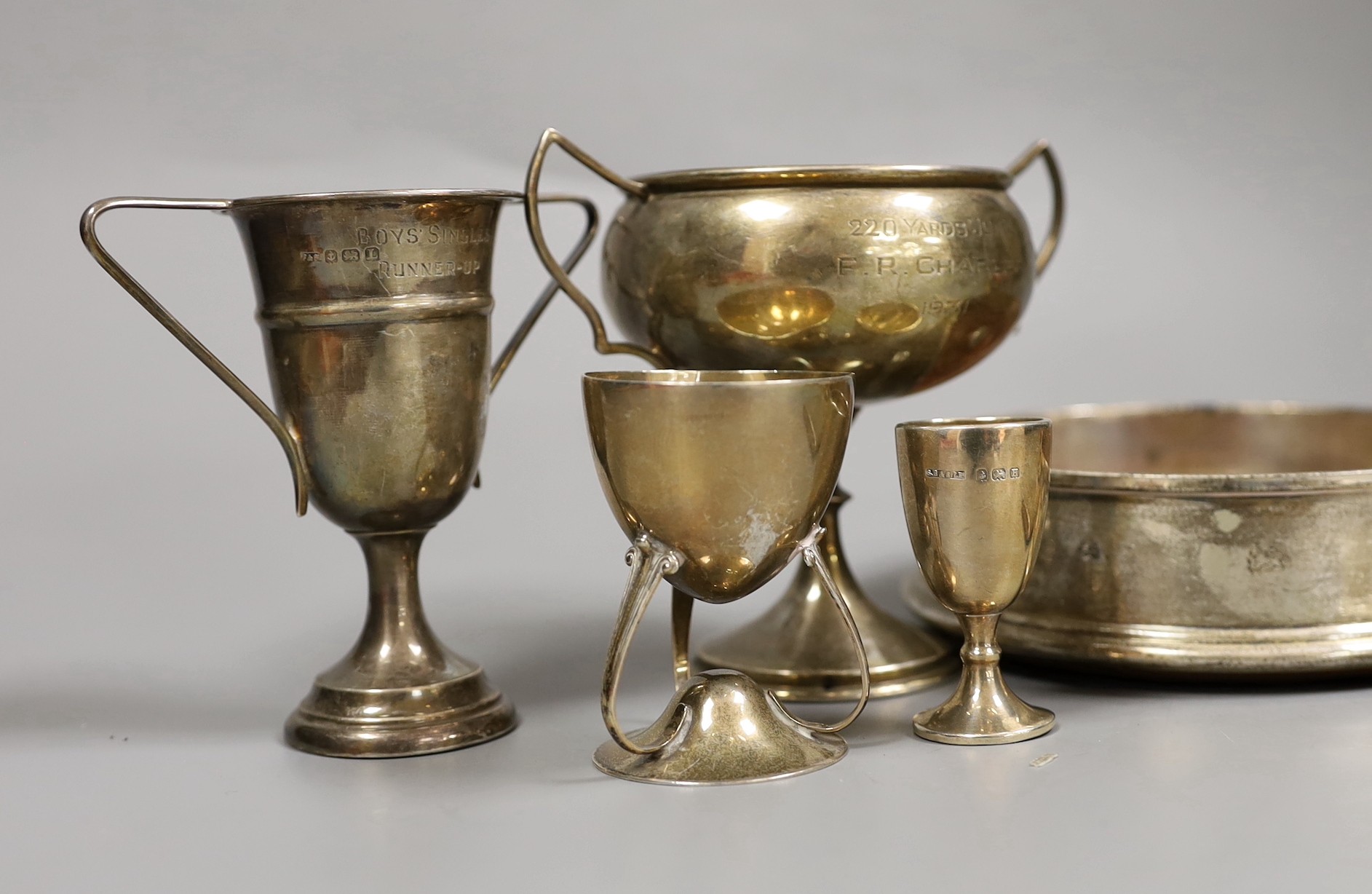 Sundry small silver including a modern wine coaster, a pair of Irish pierced silver salts(a.f.), two goblets, two small trophy cups and a cigarette case.